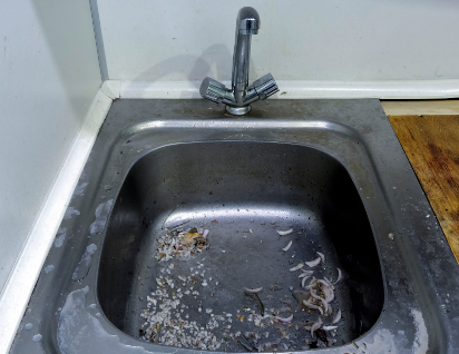 Eine stark verschmutzte Spüle vor einer Grundreinigung in der Küche